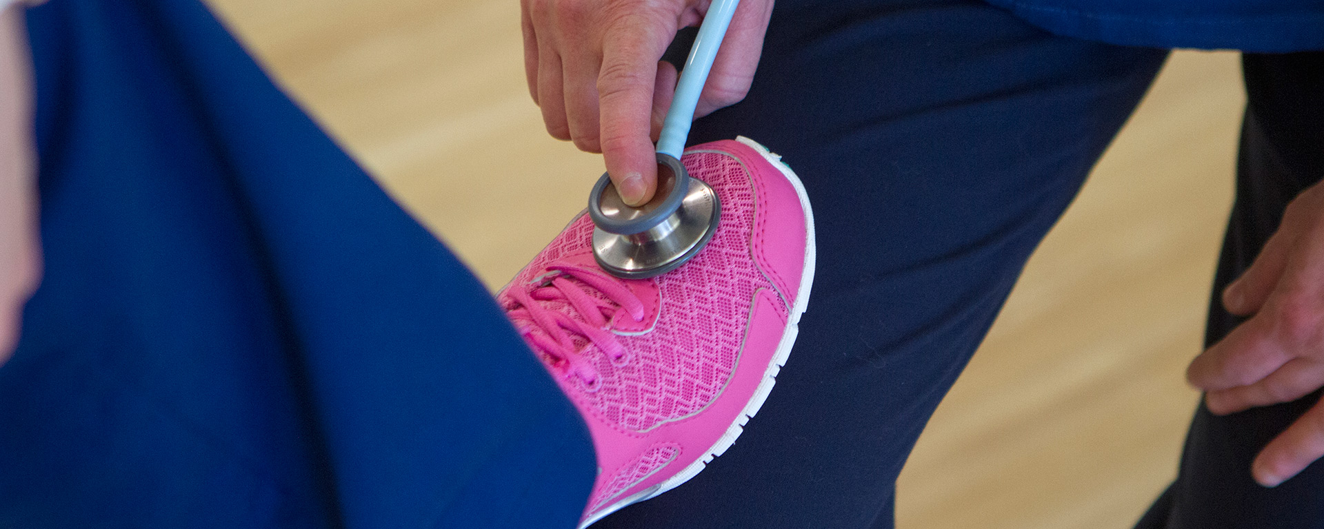 pink shoe on nurse's knee